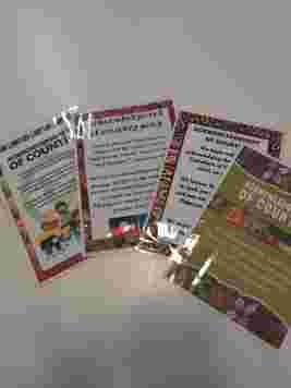 Laminated cards with "Acknowledgment of Country" text, featuring colorful borders and illustrations, laid out on a white surface.