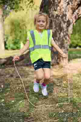 Child playing with a skipping rope with a smile outside
