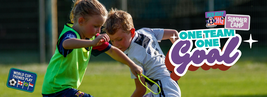 Two kids playing soccer at a summer camp, with "One Team One Goal" text, highlighting teamwork and World Cup-themed play.