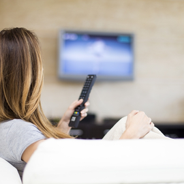 Žena s ovladačem sleduje internetovou televizi