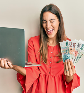 Co je konsolidace a jak vám pomůže s dluhy - mladá žena v červených šatech, české bankovky, notebook