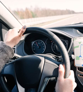 Žena řídí podle GPS navigace v mobilním telefonu