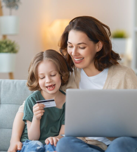 Účty a platební karty pro děti - Maminka s holčičkou sedí na gauči v obýváku, notebook, platební karta