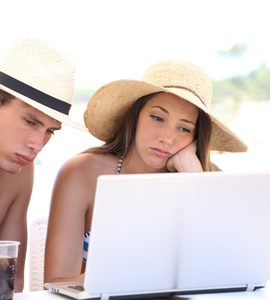 Znuděný muž a žena se dívají na dovolené do počítače
