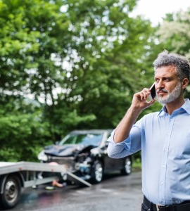 Starší muž telefonujúci pri dopravnej nehode