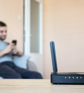 Wi-fi router - v pozadí sedí muž s telefonem