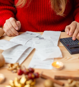 Účty za vánoční dárky - žena počítá na kalkulačce