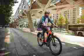 Mand cykler på orange Sparta speed pedelec i byen