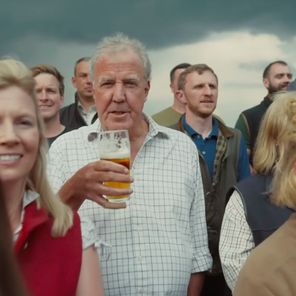 Jeremy Clarkson holding a glass of Hawkstone Lager in the choir of farmers