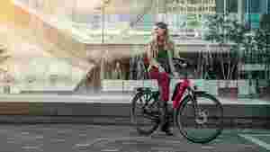 Kvinde på rød Spartas d-RULE elcykel foran springvand
