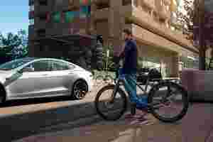 Man op e-bike D-Burst voor auto in drukke stad