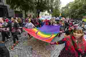A group of people holding a large Sápmi pride flag in the Trondheim pride parade