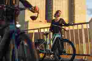 Vrouw naast e-bike E-Burst van Sparta bij zonsondergang
