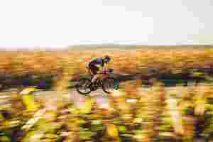 Geschichtsseite - Bild eines Mannes, der auf einem Lapierre-Rennrad durch idyllische Landschaft rast.