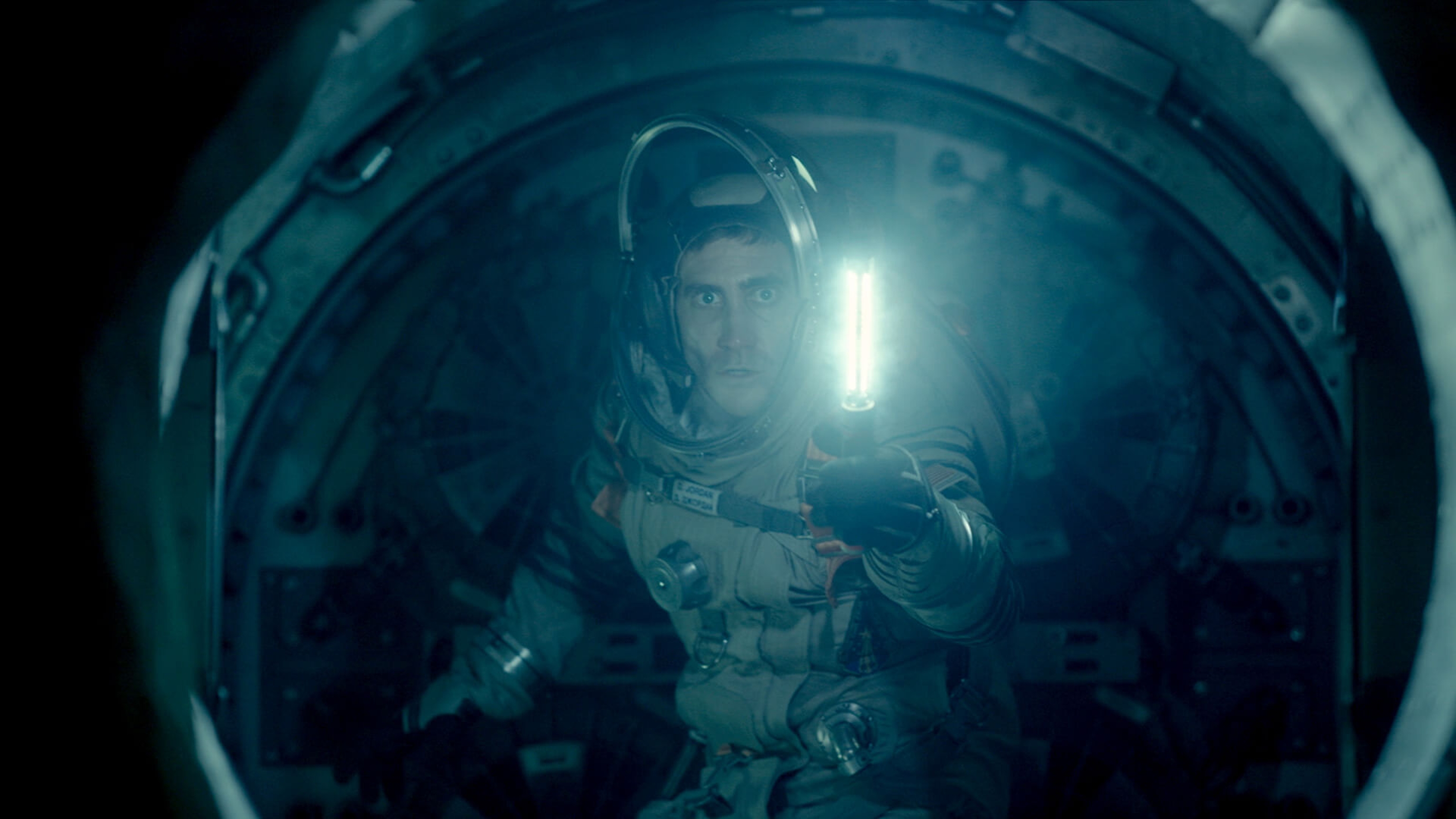 A spaceman holding a light looking through a spherical window