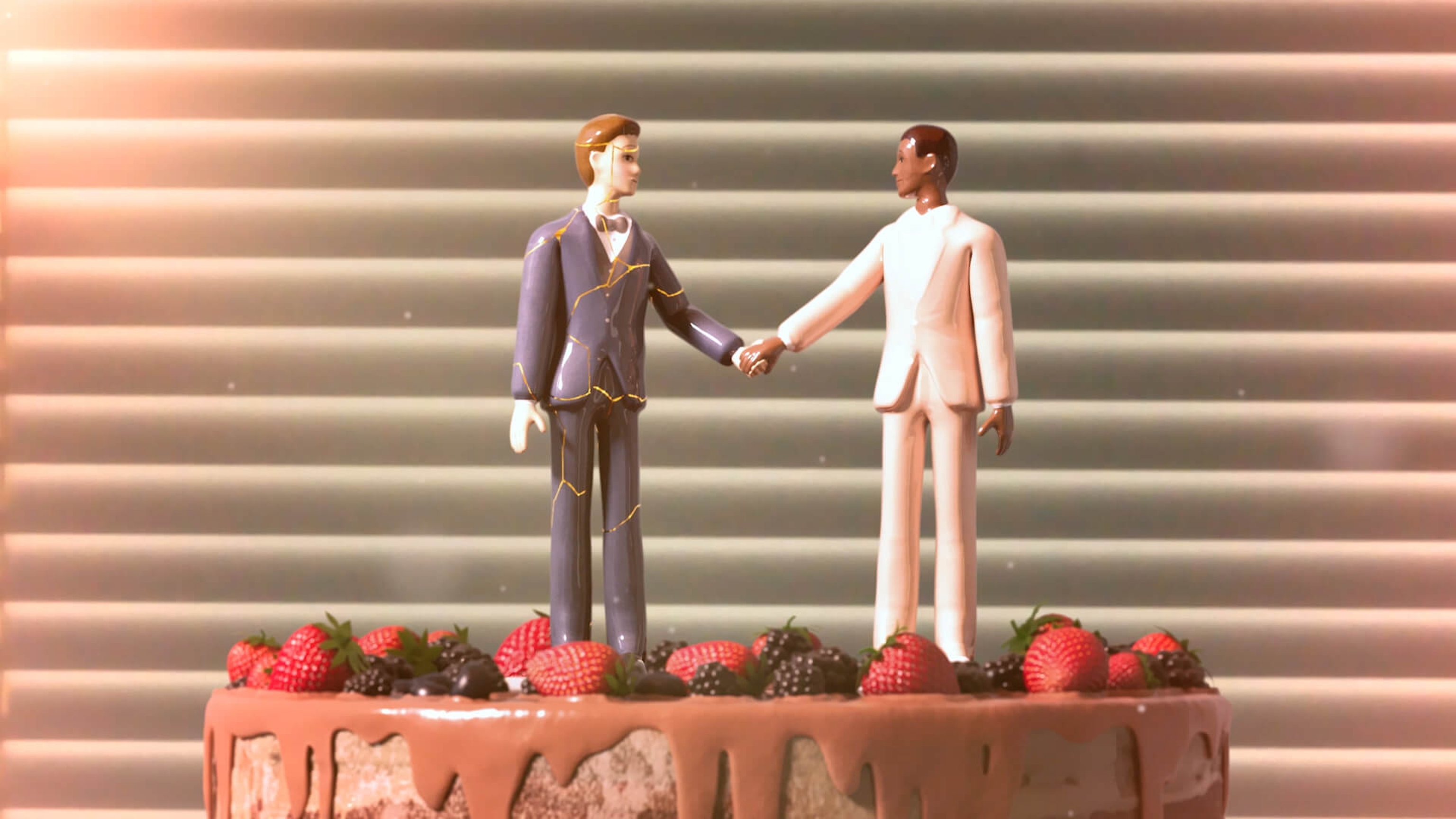 Two miniature animated characters standing on top of a cake
