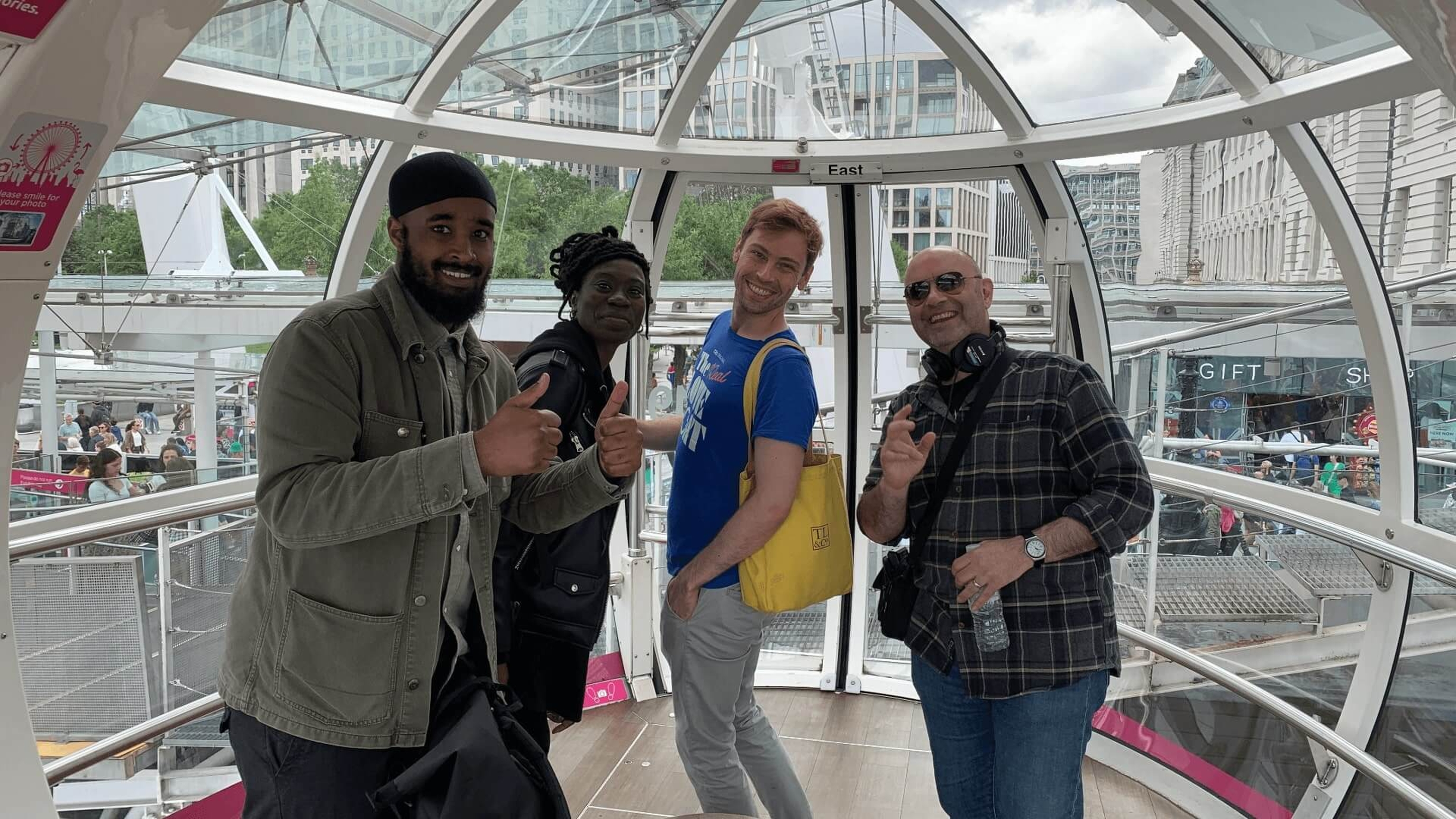 Four staff members smiling and posing in a London Eye pod