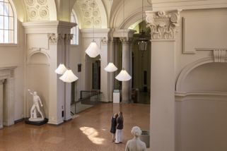 Zwei Menschen sehen zur Decke auf eine Lichtinstallation