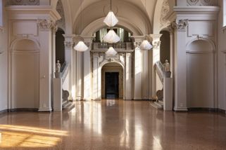 kinetische Lichtinstallation mit blütenhaften Erscheinungsbild in großer Halle