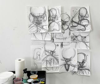 a collection of sketches of poodles pinned to a studio wall