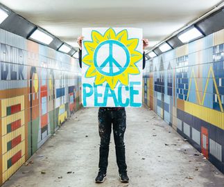 Paul Insect holds up peace poster