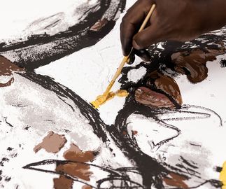 Close-up of the artist applying gold paint