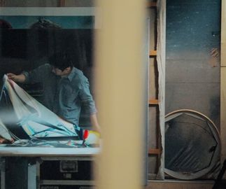 Jia Aili inspecting a large print in his studio