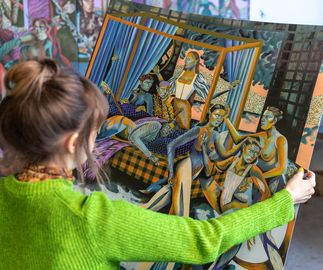 Jessie Makinson holds a print in her hands in her studio