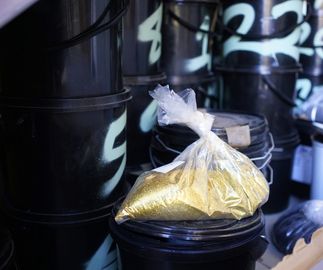 clear bag of gold glitter on black plastic tubs