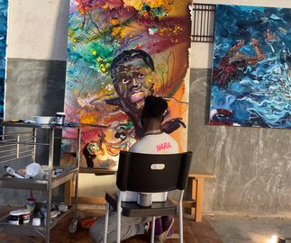 artist Ludovic Nkoth painting a big canvas painting in his studio