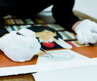 Hideaki Hand finishing in pencil his print, wearing white gloves