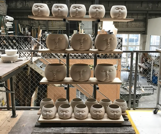 multiples of small and large ceramic pots before being fired