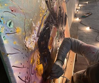 artist Ludovic Nkoth painting a big canvas painting in his studio - close up