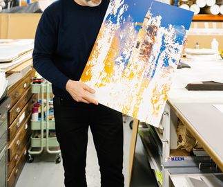Michael Kagan holding up a print in a studio