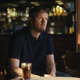 Man at the pub with a pint looking tense