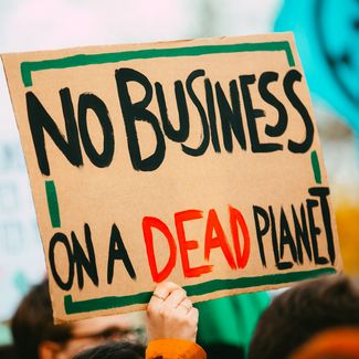 a sign that reads 'no business on a dead planet'