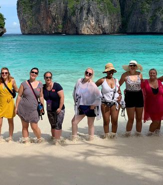 group of travelers standing together on the beach at Maya Bay in Thailand