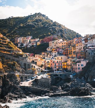 yellow and orange pastel houses along the coast in cinque terre italy