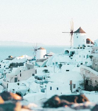 white buildings and windmills along greece's coastline