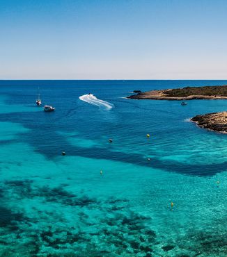 boats docked in the crystal blue water off the coast of Menorca in Spain