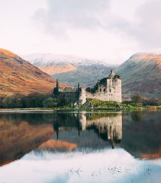 run down castle along a lake in the scottish highlands