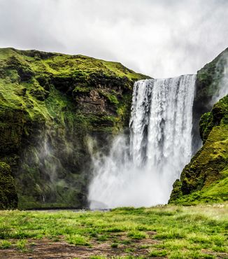 skogafoss waterfall cascading down into the river in iceland