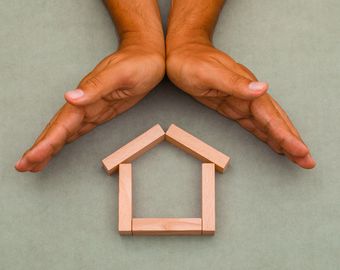 mains protégeants une maison