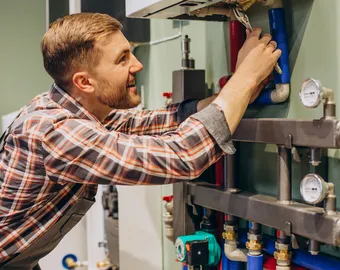 plombier faisant l'entretien d'une chaudière