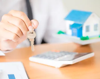 agent immobilier qui tend des clefs