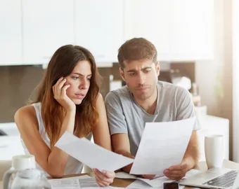 Deux locataires lisent le courrier sur l'exonération de taxe d'habitation