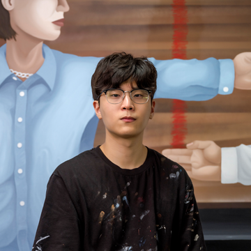 Portrait of Sun-Kyo Park in front of one of his paintings