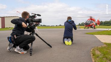 Videoproduktion Behind The Scenes: Steven steht mit Kamera hinter Junge, der Helikopter fotografiert