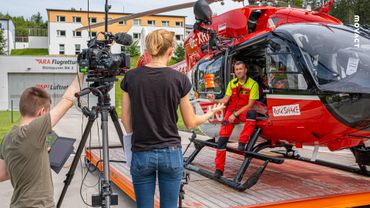 Redakteurin und Kameramann beim Filmen eines Helikopters