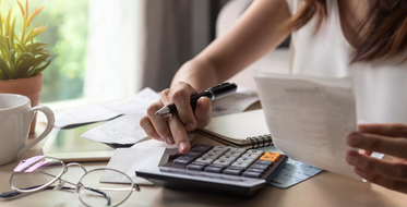 Žena s účty počítá na kalkulačce